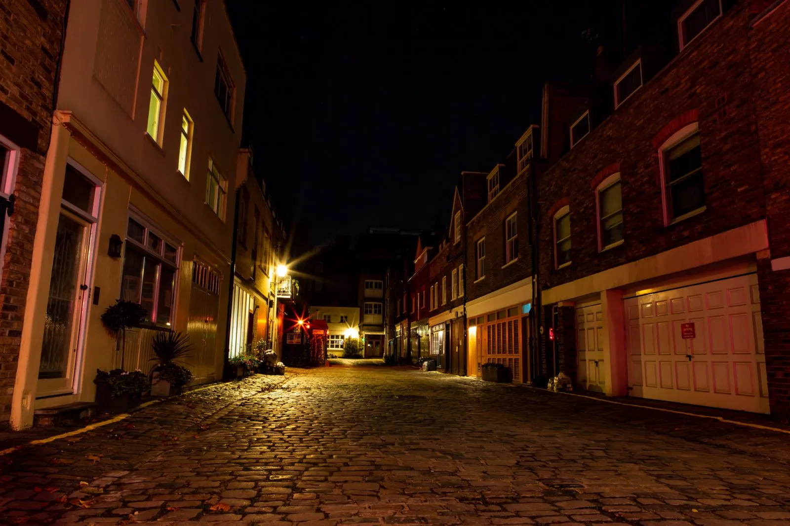 Serene cobblestone alley in London with warm lighting highlighting historic architecture.